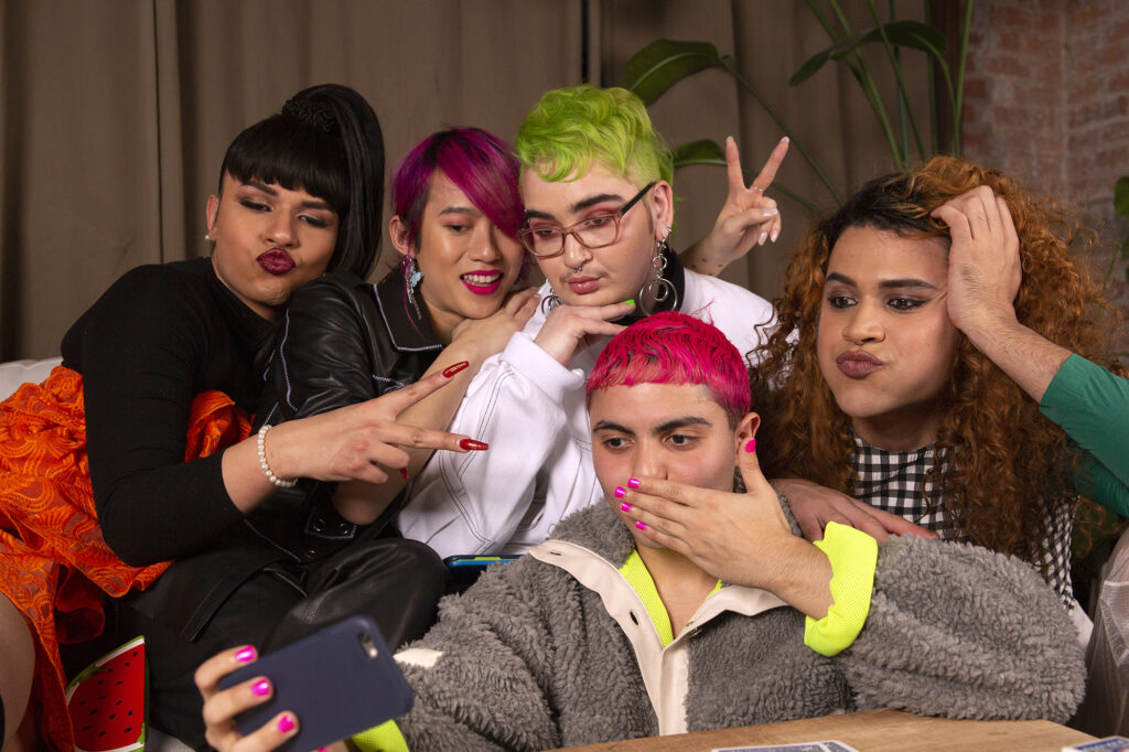 A group of friends of varying genders taking selfies
