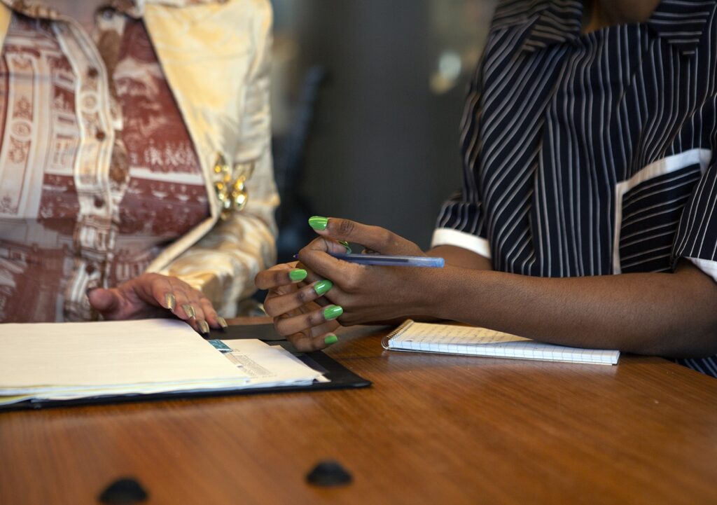 The hands of two persons in a consultation meeting